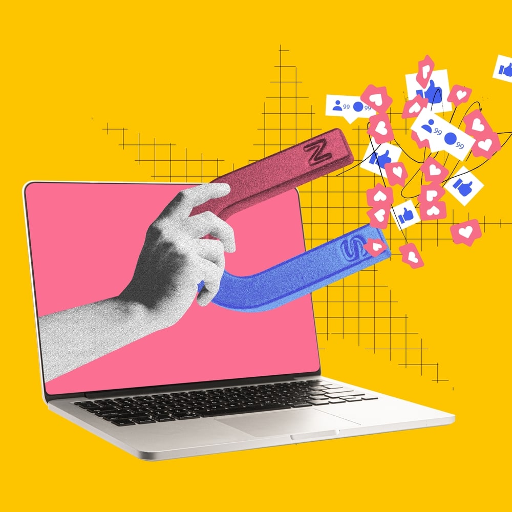 Hand with magnet attracting social media icons from laptop screen. Contemporary art. Visual for influencer marketing platforms to attract content creators. Digital marketing, online services concept